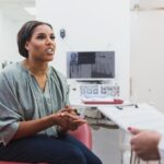 woman talking about warning signs in the mouth with dentist