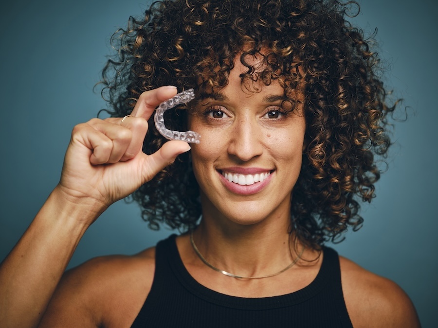 suresmile clear aligners, woman holding clear aligners