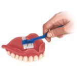 cleaning dentures with denture brush